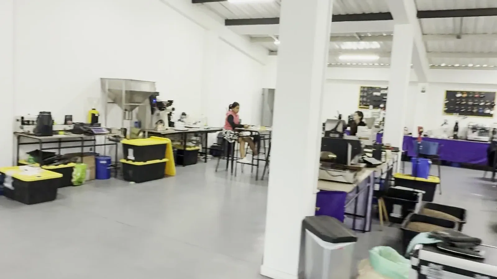 La nave del laboratorio de tostión, con las tostadoras y las mesas de trabajo bajo la estructura metálica.